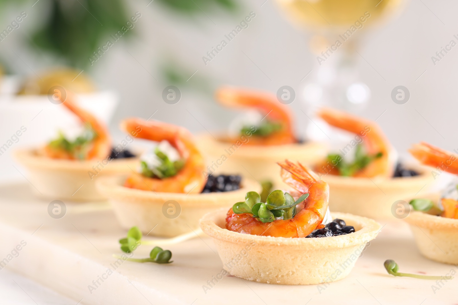 Photo of Delicious canapes with shrimps and black caviar on table, closeup