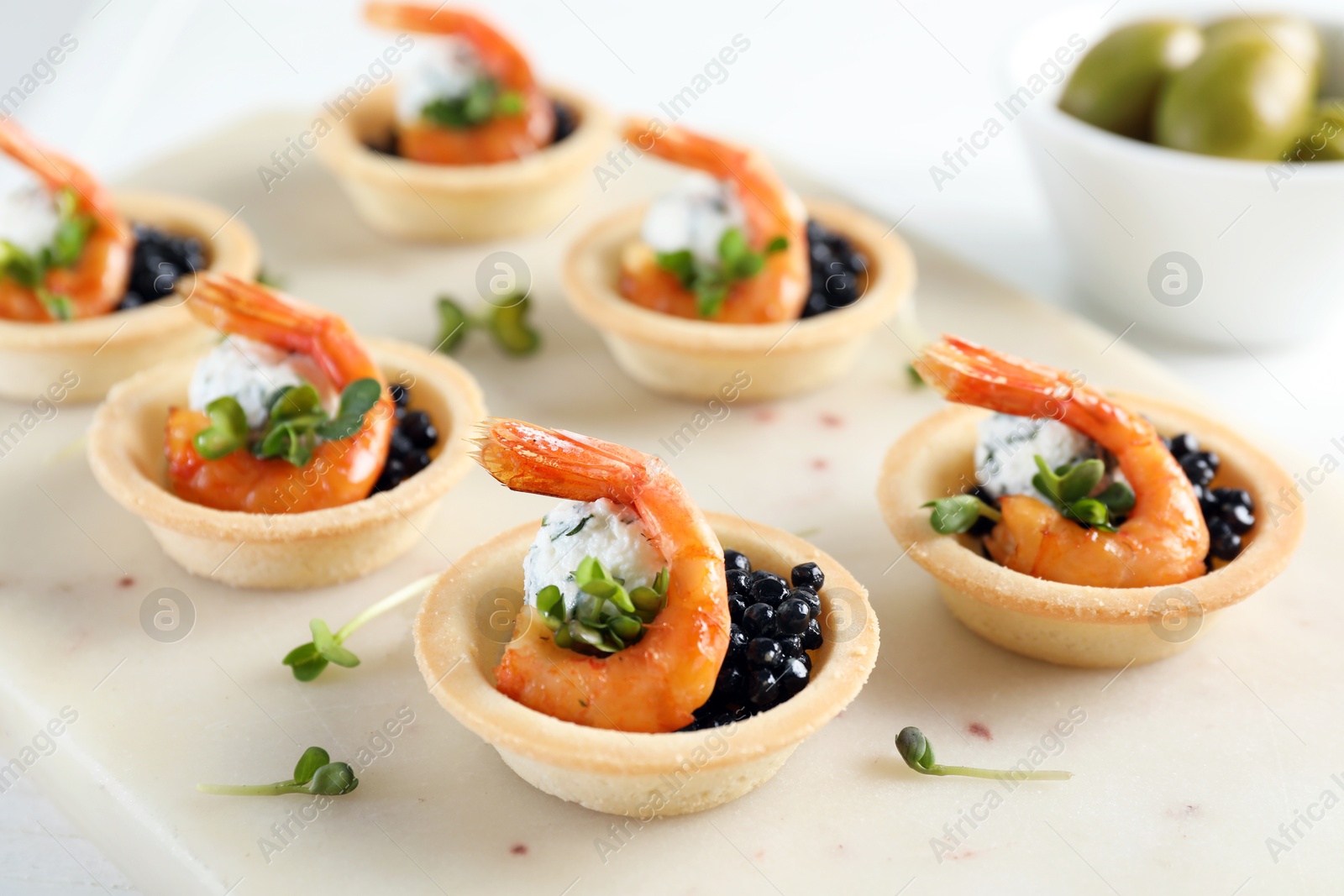 Photo of Delicious canapes with shrimps and black caviar on table, closeup