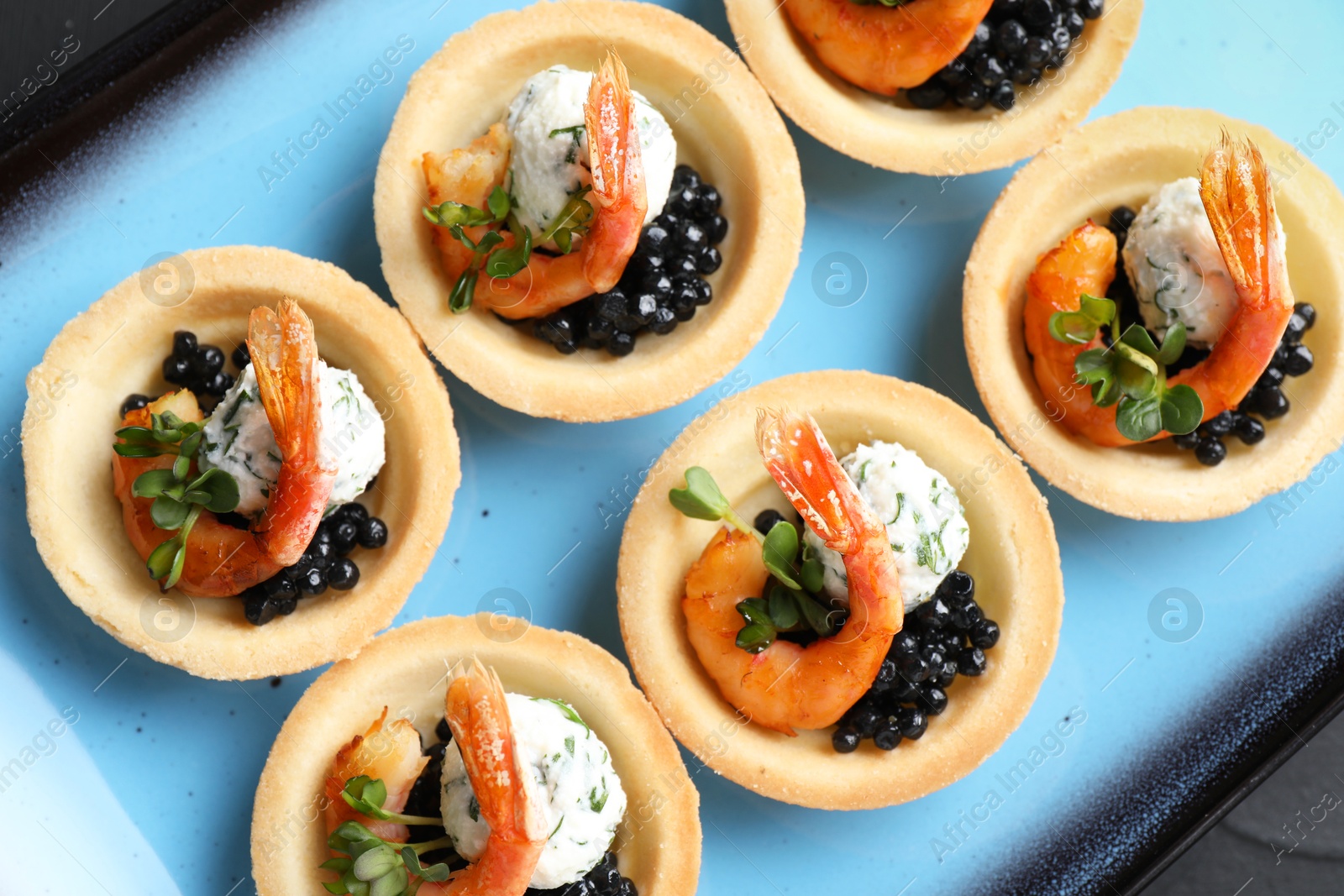 Photo of Delicious canapes with shrimps and black caviar on table, top view