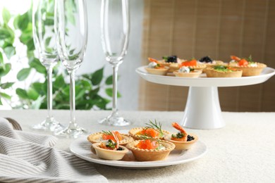 Photo of Delicious canapes with shrimps, salmon and caviar on beige textured table