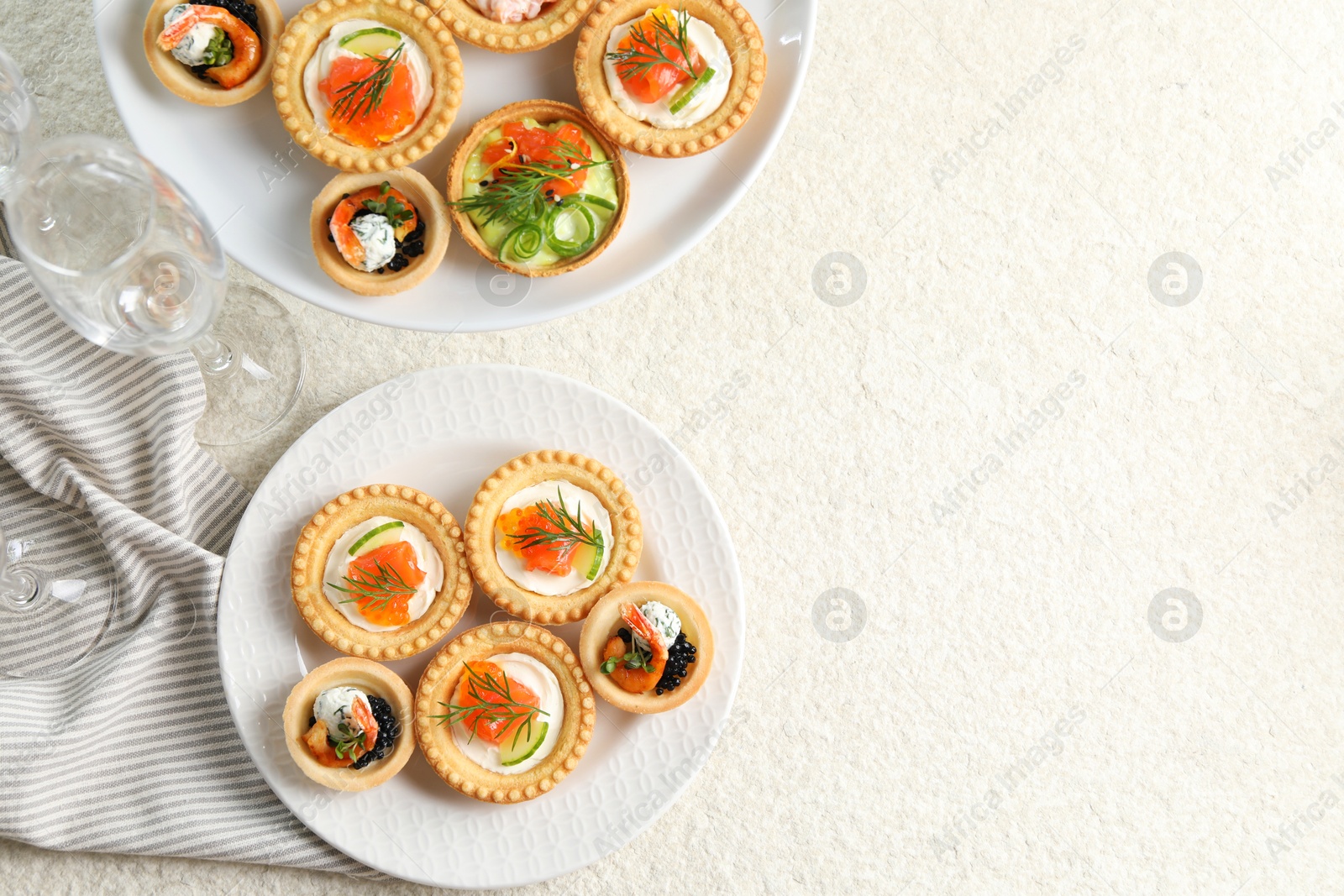 Photo of Delicious canapes with shrimps, salmon and caviar on beige textured table, flat lay. Space for text