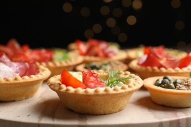 Photo of Delicious canapes with dry smoked sausage and cream cheese and tomato on table, closeup