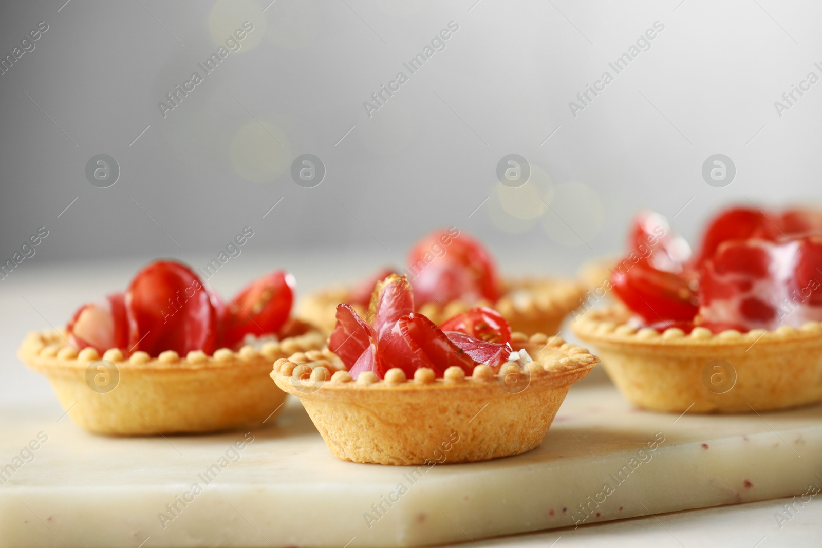 Photo of Delicious canapes with jamon on white table, closeup