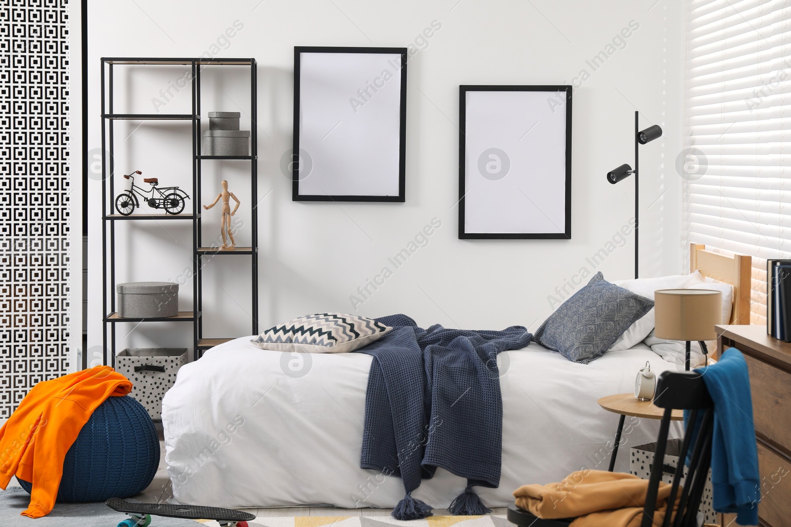 Photo of Teen's room interior with modern furniture and empty frames on wall