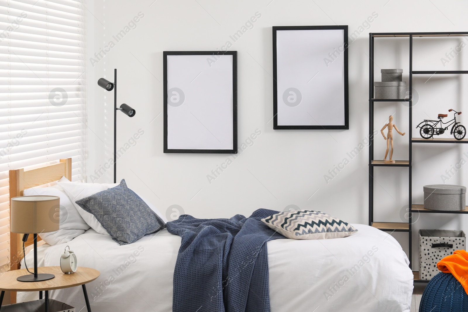 Photo of Teen's room interior with modern furniture and empty frames on wall