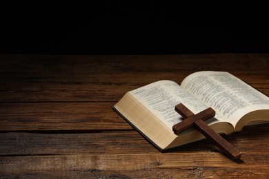 Bible and cross on wooden table, space for text. Religion of Christianity