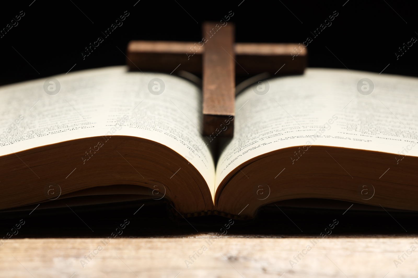 Photo of Bible and cross on table, closeup. Religion of Christianity