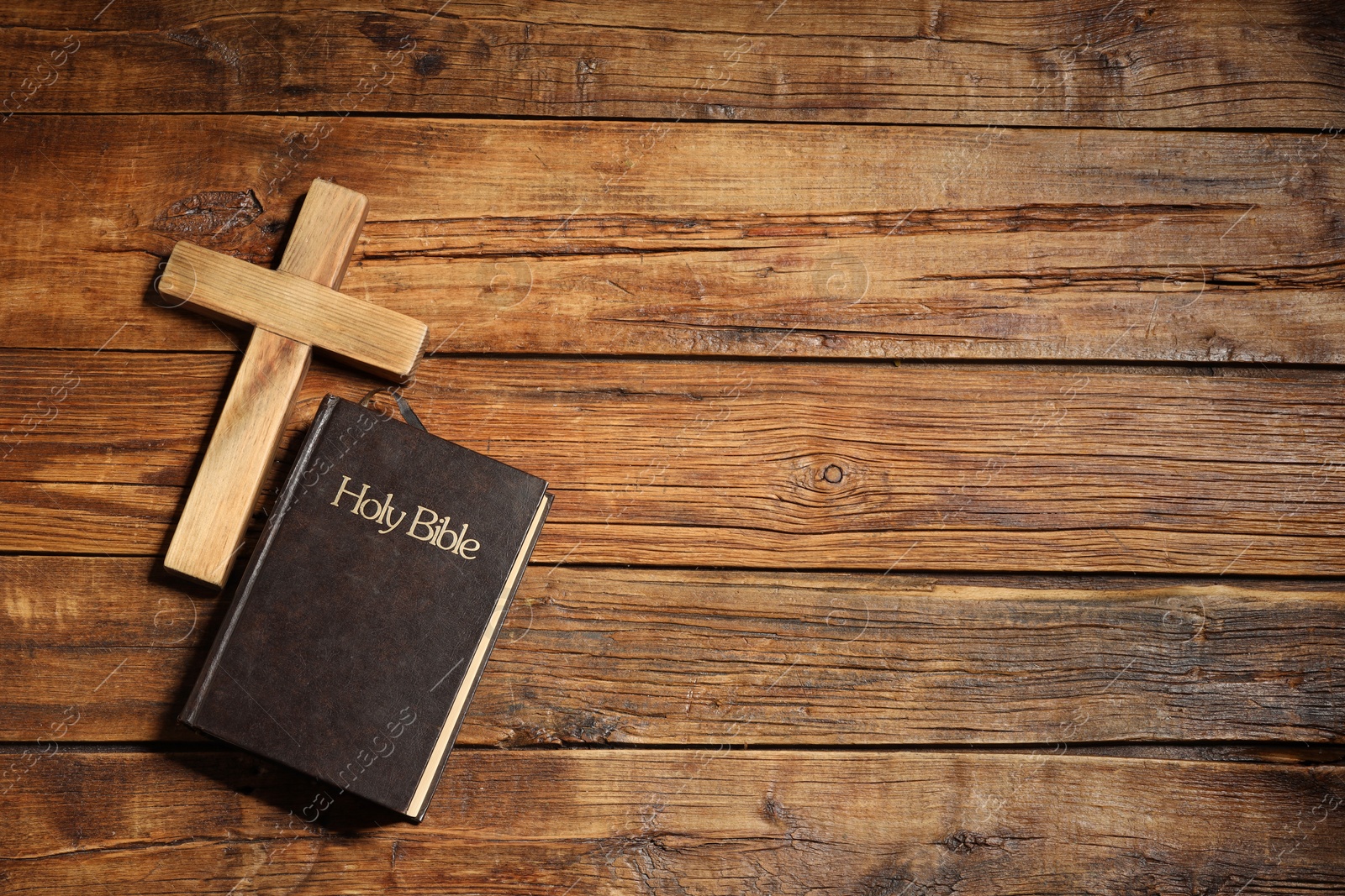 Photo of Bible and cross on wooden table, flat lay with space for text. Religion of Christianity