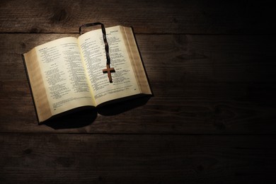 Bible and cross on wooden table, top view with space for text. Religion of Christianity