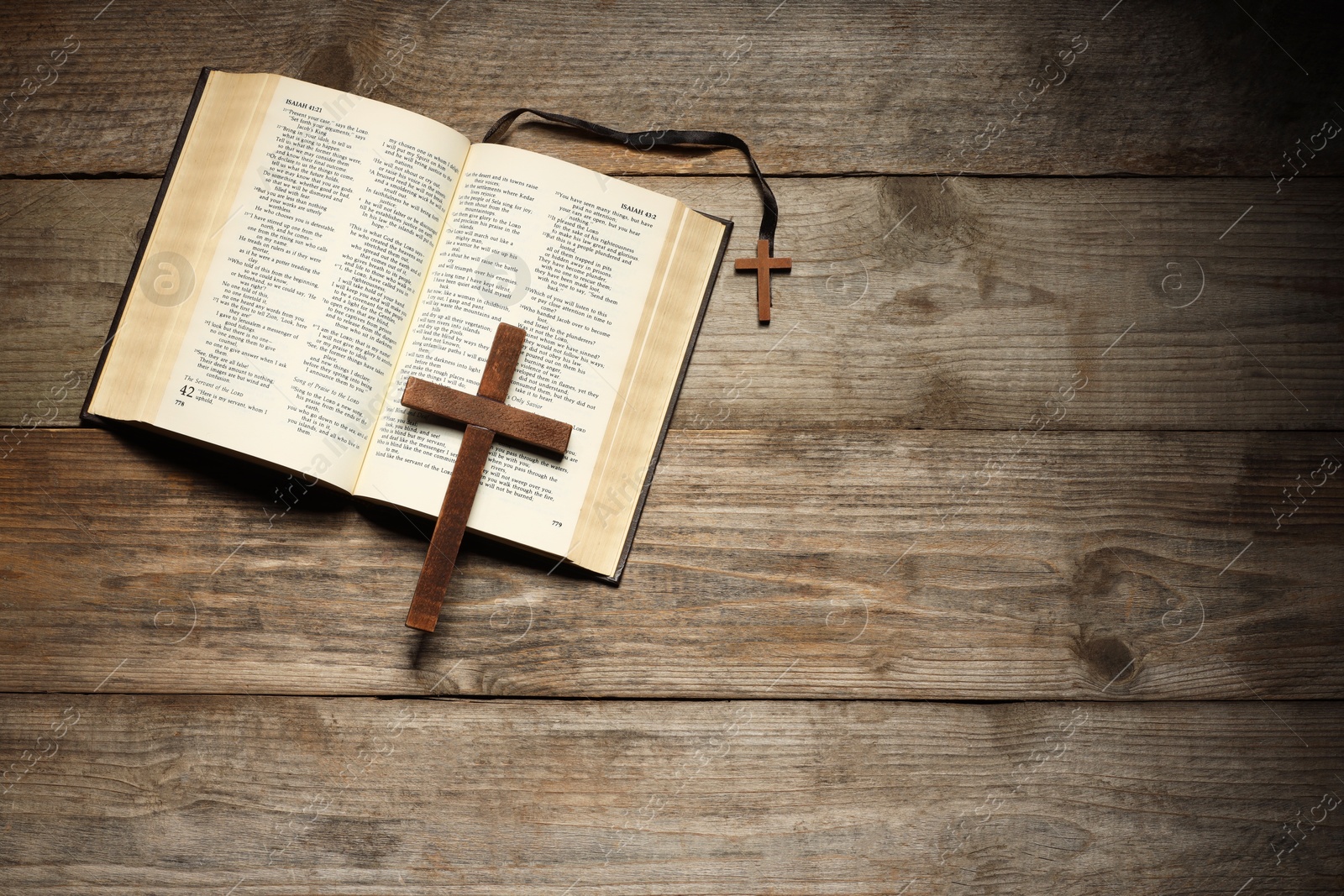 Photo of Bible and crosses on wooden table, top view with space for text. Religion of Christianity