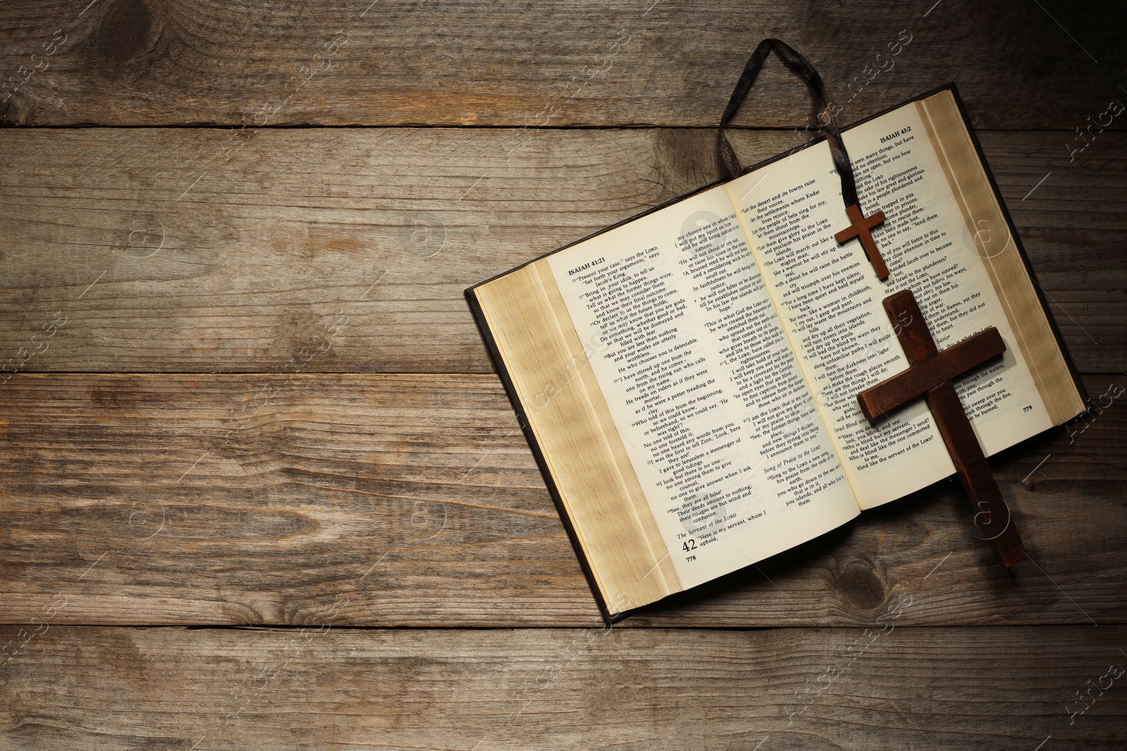 Photo of Bible and crosses on wooden table, top view with space for text. Religion of Christianity