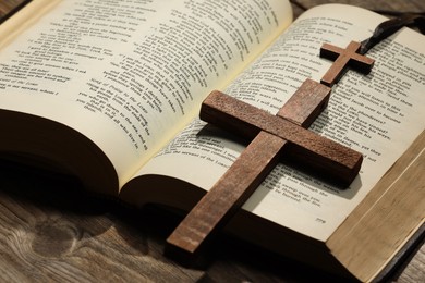 Bible and crosses on wooden table, closeup. Religion of Christianity