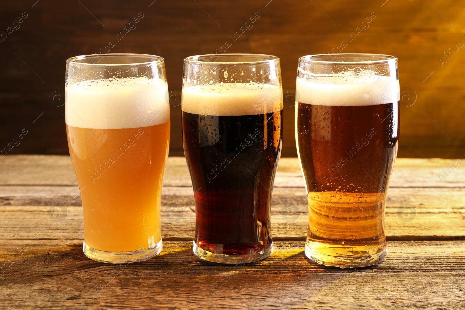 Photo of Glasses with different types of beer on wooden table