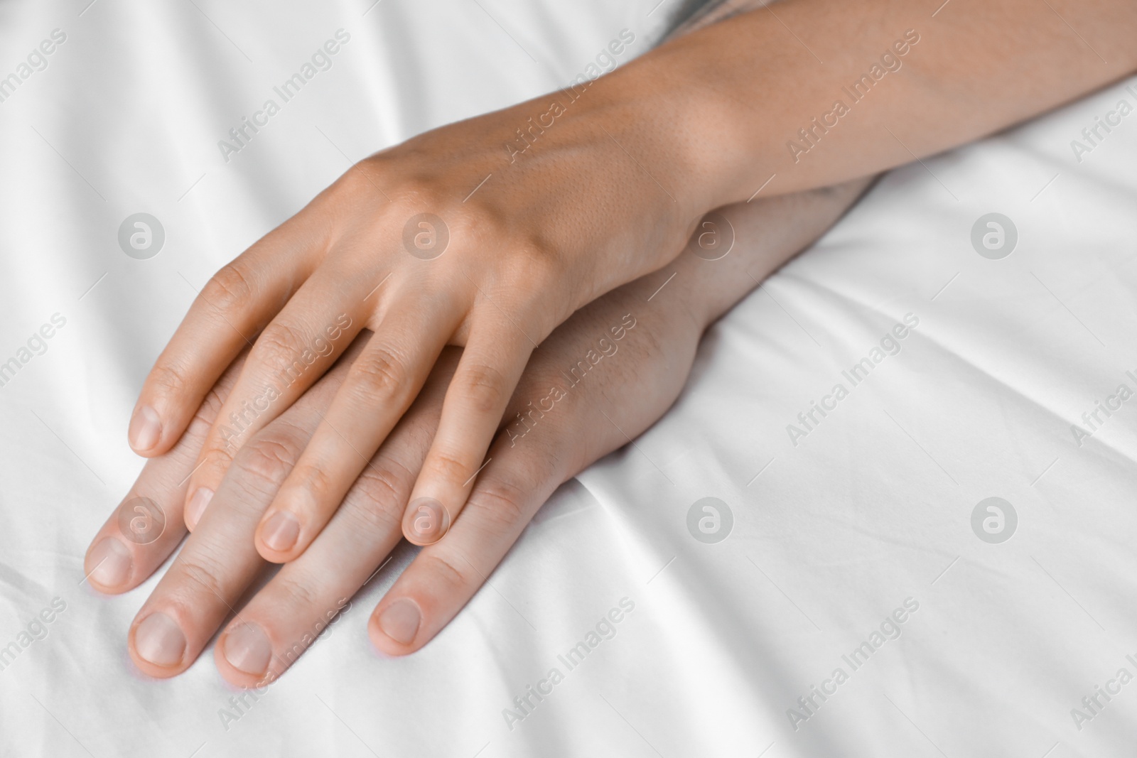 Photo of Lovely couple holding hands in bed, closeup