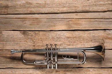 One trumpet on wooden table, top view. Space for text