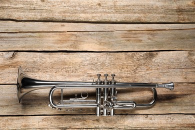 One trumpet on wooden table, top view. Space for text