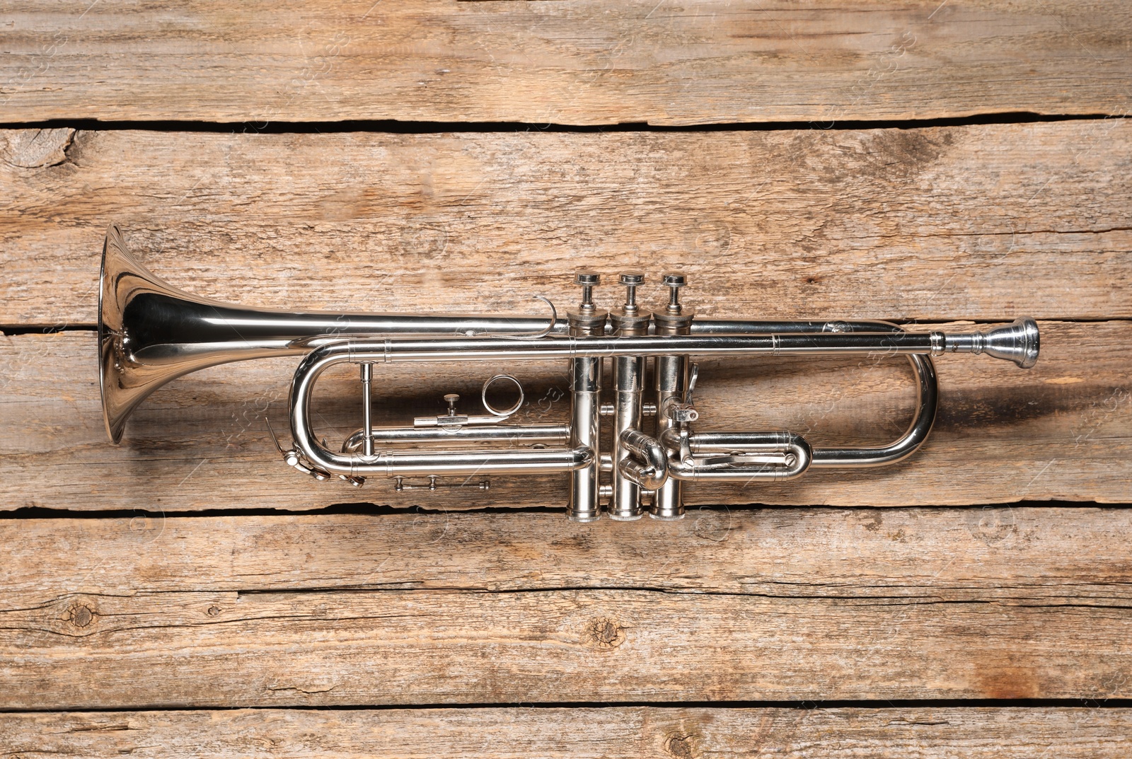 Photo of One trumpet on wooden table, top view