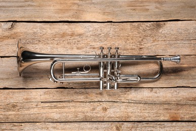 Photo of One trumpet on wooden table, top view