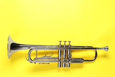 Photo of One trumpet on yellow background, top view. Space for text