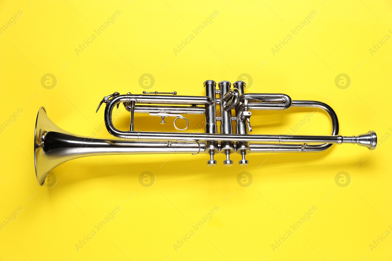 Photo of One trumpet on yellow background, top view