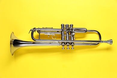 One trumpet on yellow background, top view