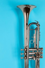 Photo of One trumpet on light blue background, top view