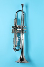 Photo of One trumpet on light blue background, top view