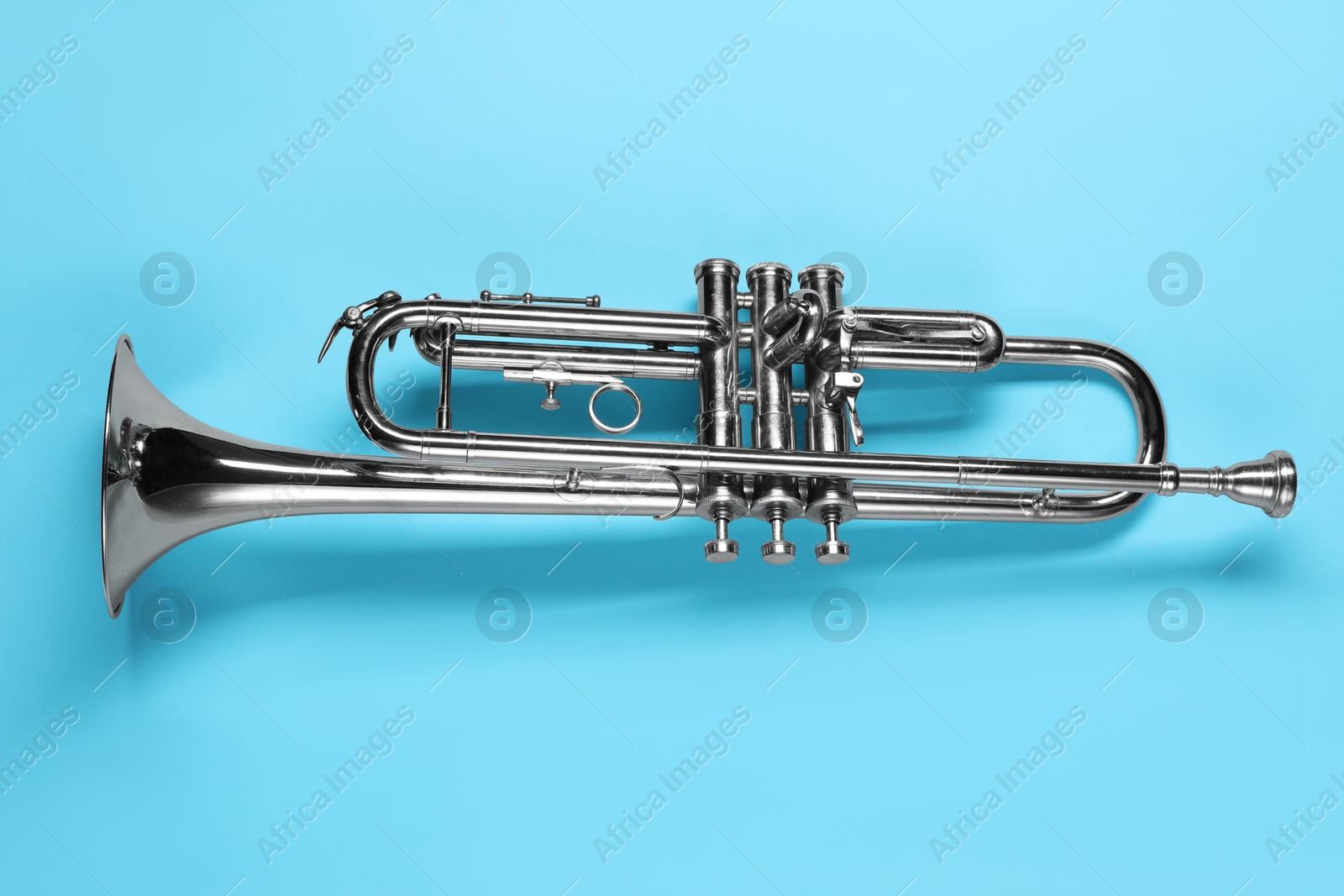 Photo of One trumpet on light blue background, top view