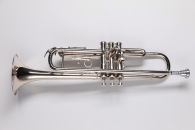 Photo of One trumpet on light background, top view