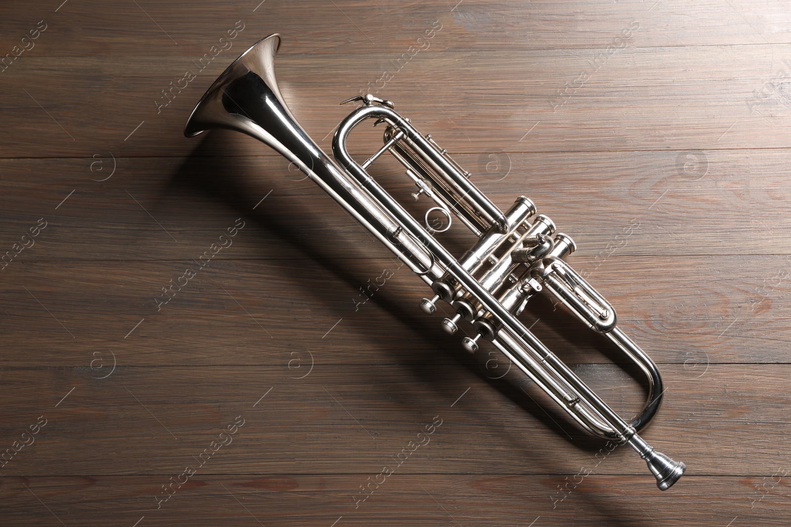 Photo of One trumpet on wooden table, top view