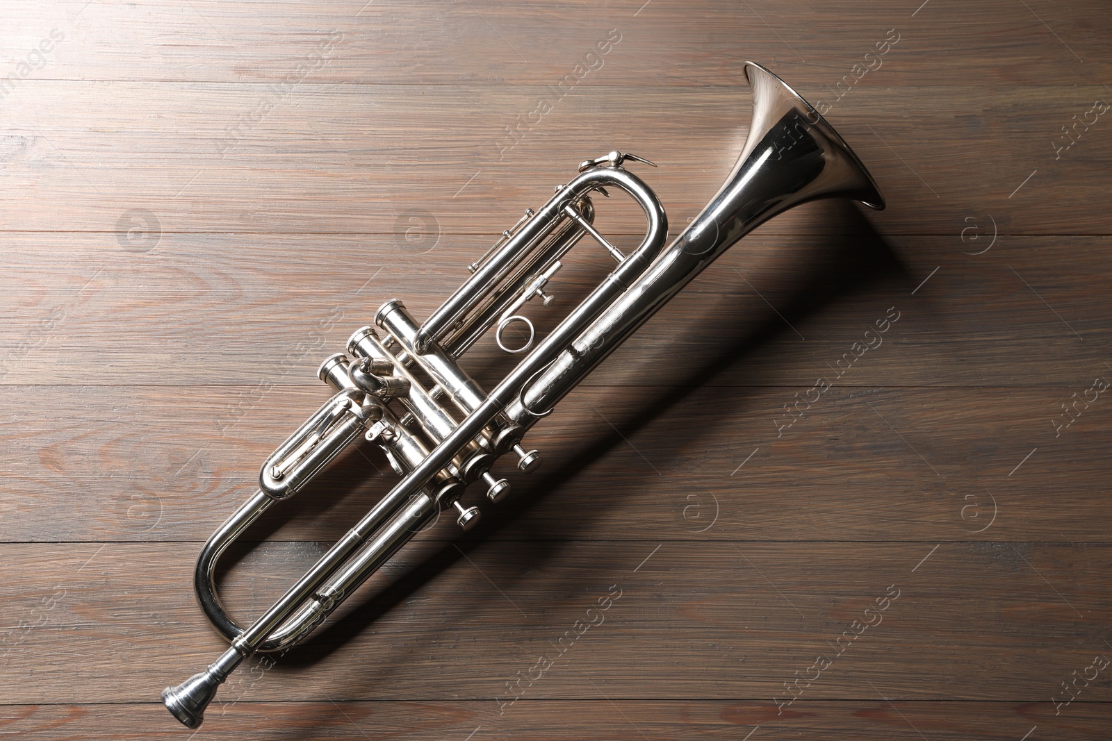 Photo of One trumpet on wooden table, top view