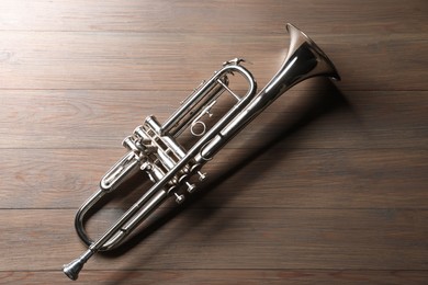 Photo of One trumpet on wooden table, top view