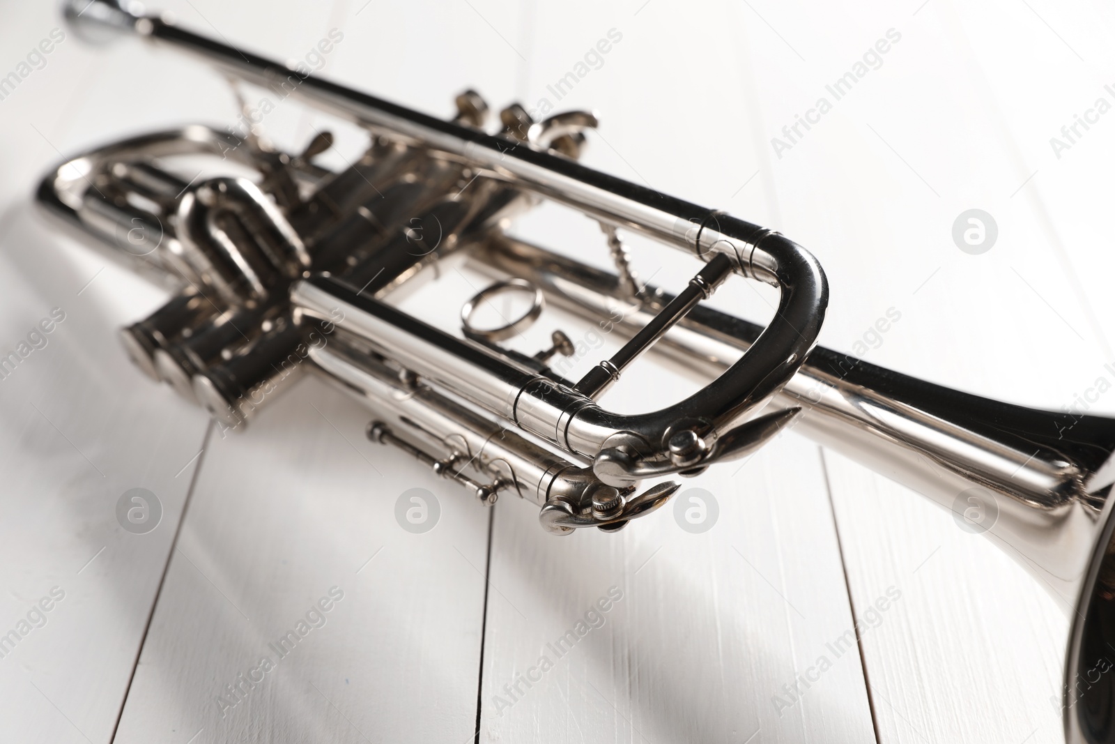 Photo of One trumpet on white wooden table, closeup