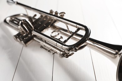 Photo of One trumpet on white wooden table, closeup