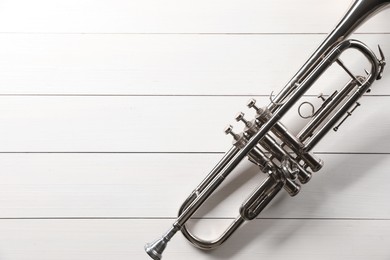 Photo of One trumpet on white wooden table, top view. Space for text