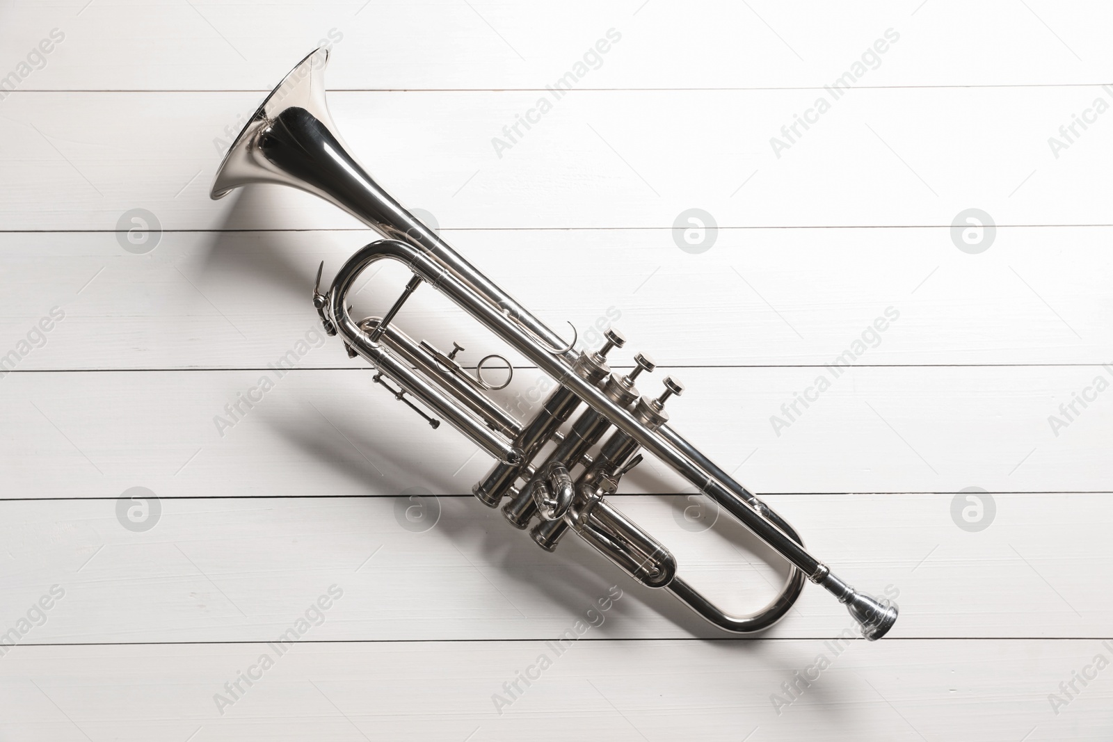 Photo of One trumpet on white wooden table, top view