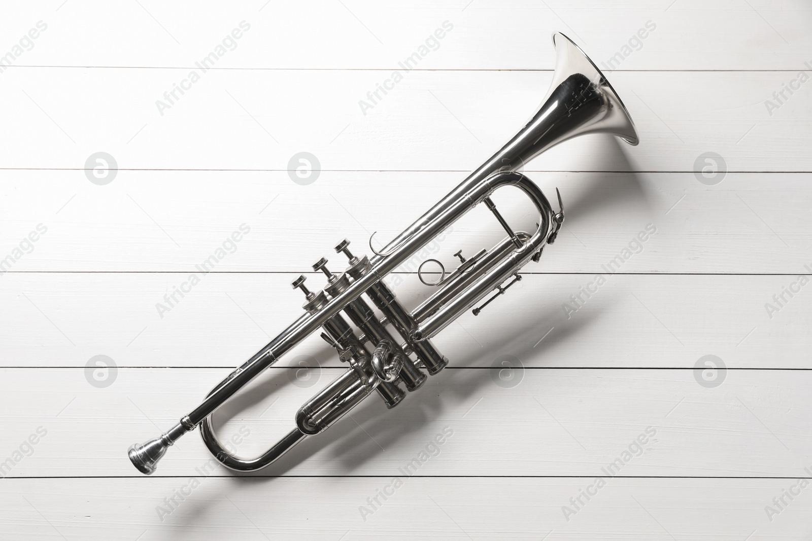 Photo of One trumpet on white wooden table, top view