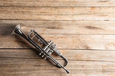 One trumpet on wooden table, top view. Space for text