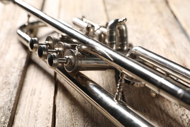 One trumpet on wooden table, closeup. Musical instrument