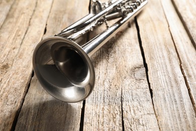 One trumpet on wooden table, closeup. Musical instrument