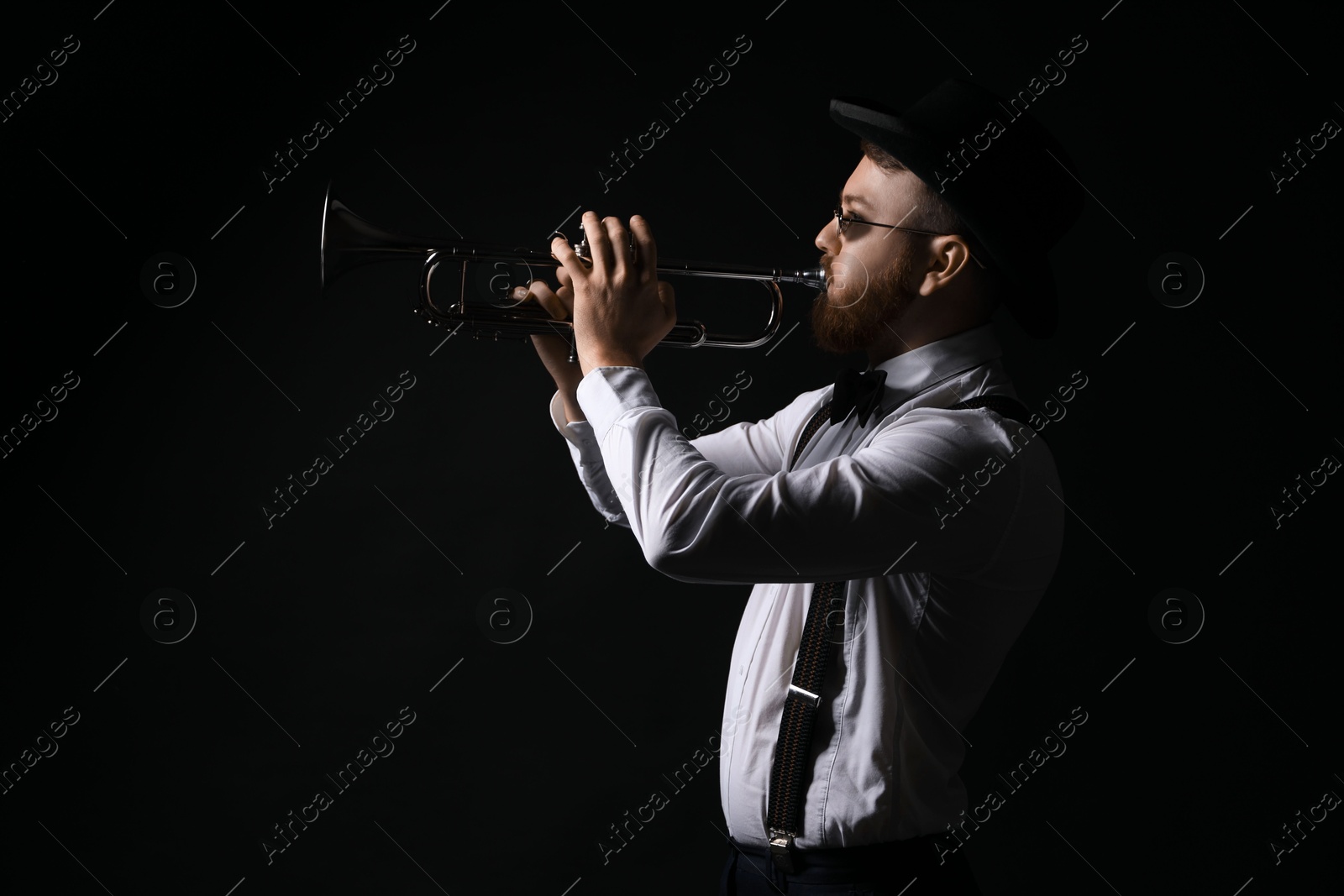 Photo of Professional musician playing trumpet on black background