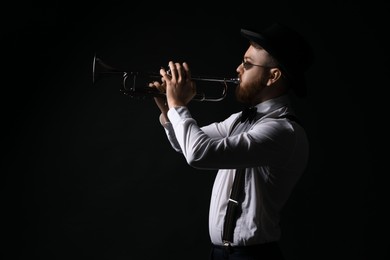 Photo of Professional musician playing trumpet on black background