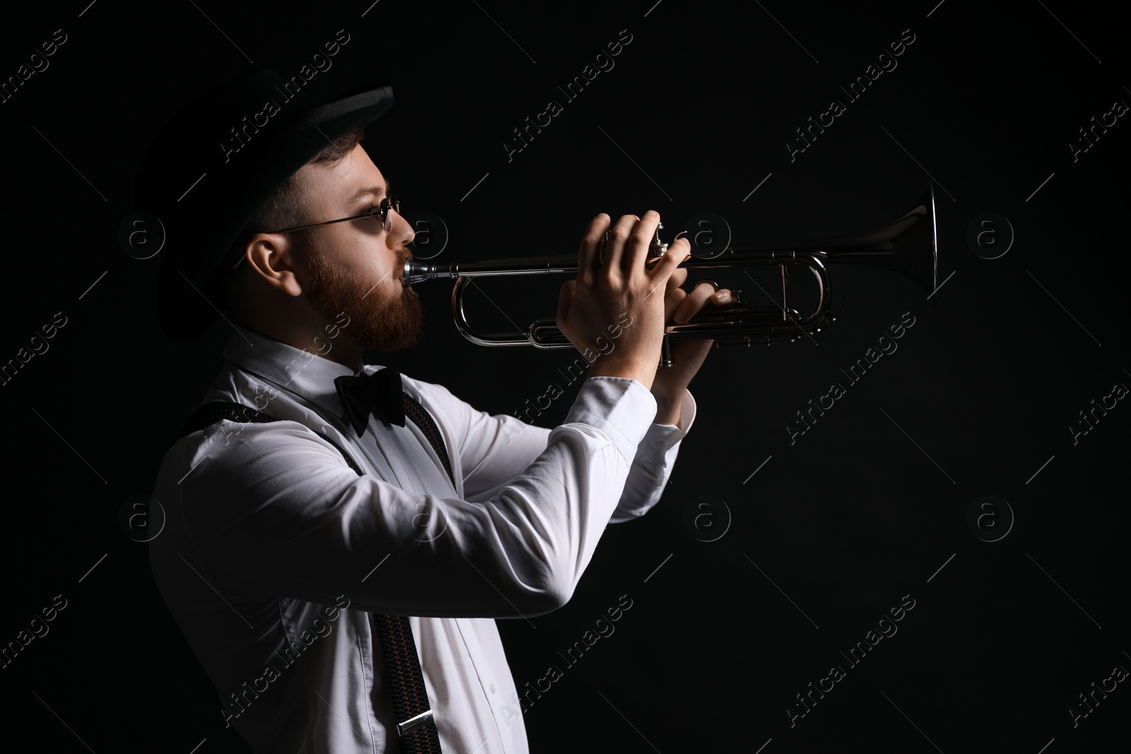 Photo of Professional musician playing trumpet on black background