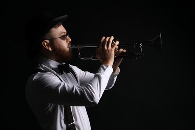 Photo of Professional musician playing trumpet on black background