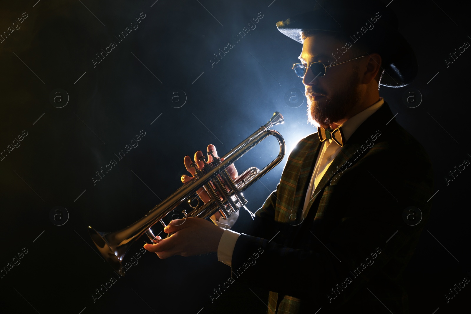 Photo of Professional musician playing trumpet on black background