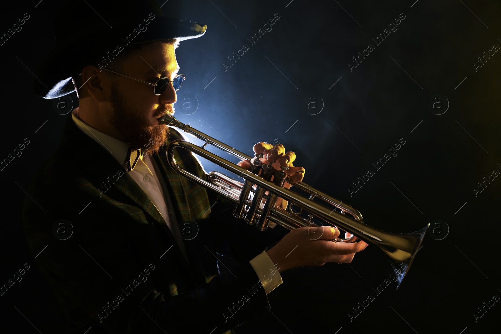 Photo of Professional musician playing trumpet on black background