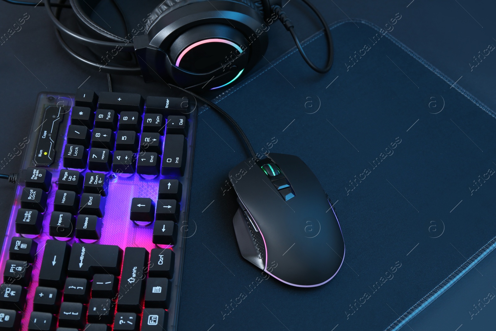 Photo of Computer mouse, RGB keyboard and headset on black background