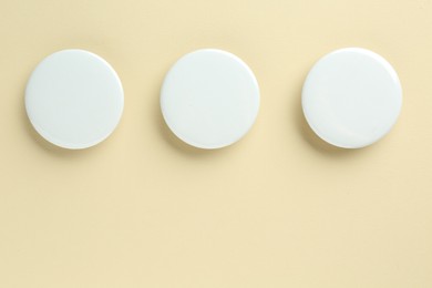 Photo of White button badges on beige background, flat lay. Mockup for design