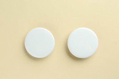 Photo of White button badges on beige background, flat lay. Mockup for design