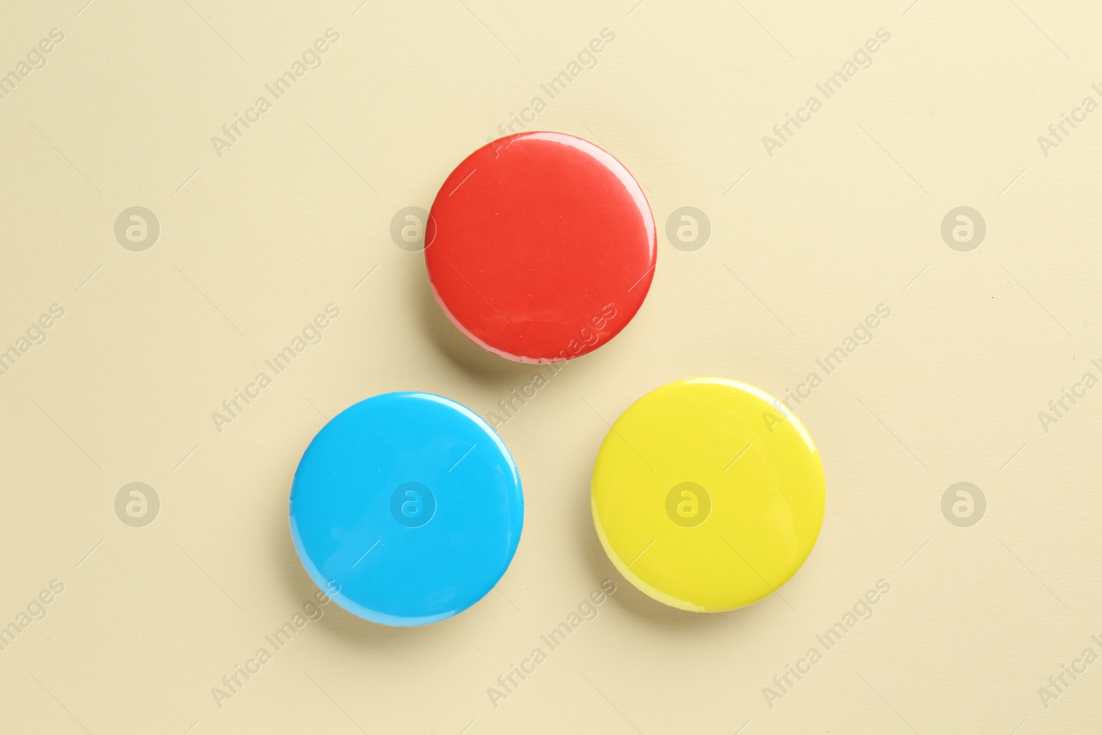 Photo of Colorful button badges on beige background, flat lay. Mockup for design